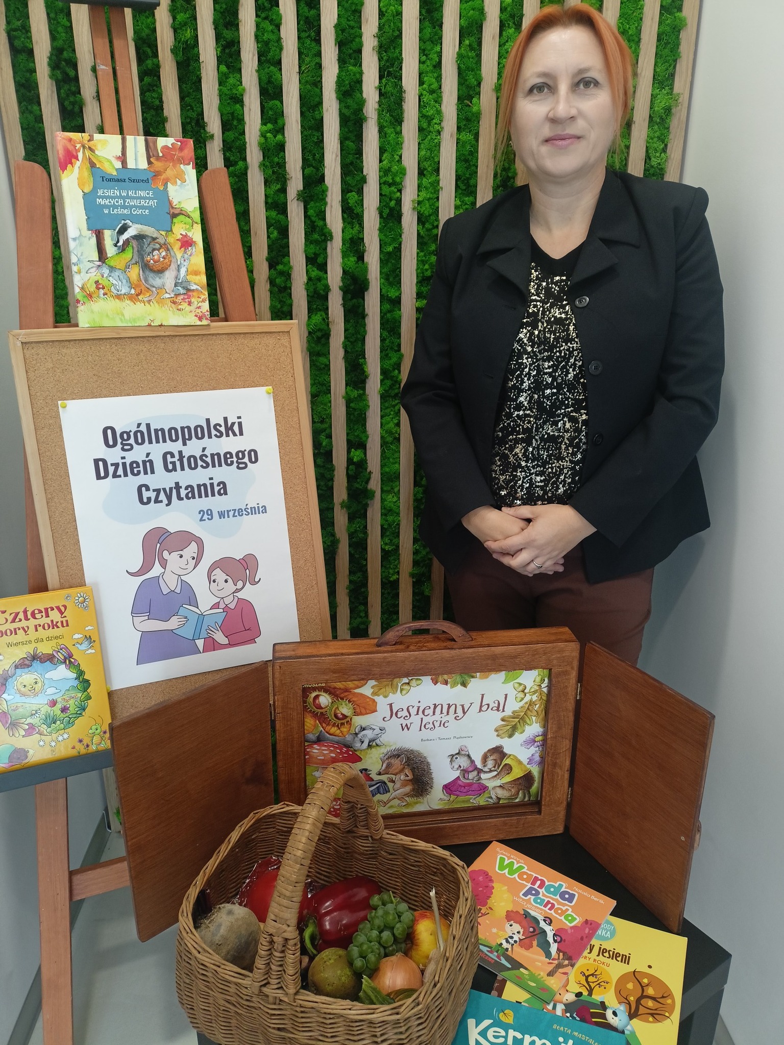 bibliotekarka siedzi obok teatrzyku kamishibai
